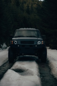 雪地行驶的黑色轿车图片