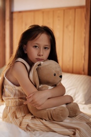 女孩在床上拥抱泰迪熊图片