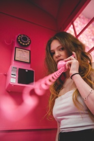 粉色电话亭打电话的美女图片