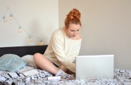 美女坐在床上用电脑学习图片