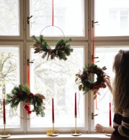 女人在窗边挂圣诞装饰品图片