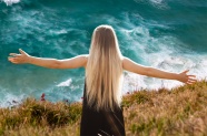 美女展开双臂站在海边图片