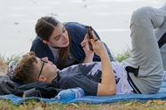 躺在草地上玩手机的情侣图片