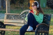 美女坐在长椅上听音乐图片