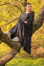 坐在树上的黑色连衣裙美女图片
