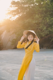 越南戴斗笠的黄色奥黛美女图片