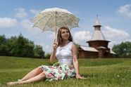 欧美美女坐在草地上撑伞图片