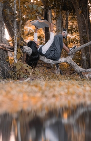 秋季美女躺在树林树干上看书图片