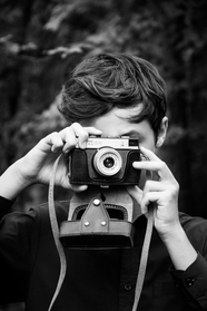 手持复古相机的少年黑白摄影图片