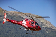 高空飞行的红色直升机摄影图片