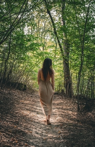 春天美女漫步在绿色森林背影图片