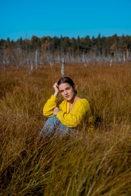 秋天坐在枯黄草丛中的欧美美女图片