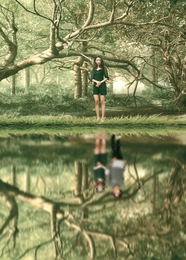 站在绿色森林看着河边倒影的美女图片