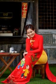 越南坐在椅子上低眸的红色奥黛美女图片