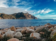 蓝天海岸岩石海水小山丘摄影图片