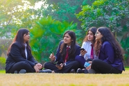 大学生坐在校园草地上探讨问题图片