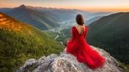坐在山之巅的红色婚纱美女背影图片