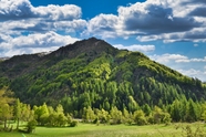 蓝色天空白色卷积云绿色山脉摄影图片
