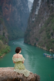 亚洲美女坐在山头看峡谷风景背影图片