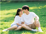 坐在草地上的一对年轻情侣图片