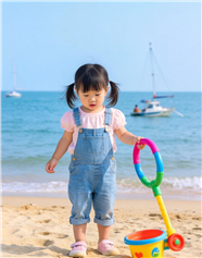 小女孩海边沙滩玩沙子图片